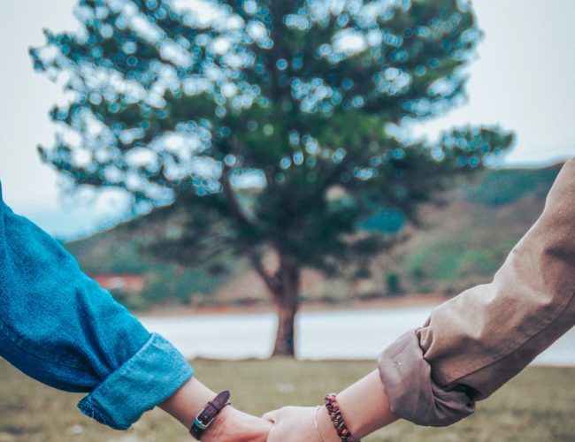 two persons holding hands